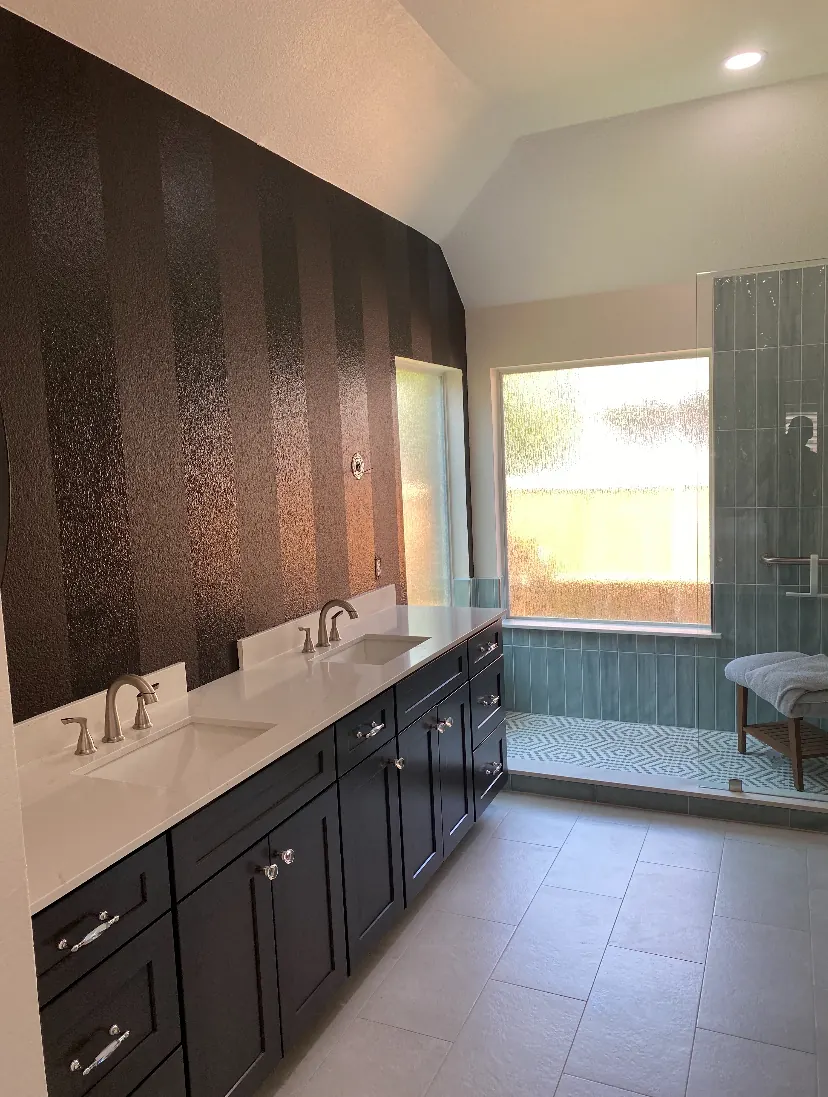 Primary bathroom with a striped dark accent wall behind a double vanity in a McKinney, TX home