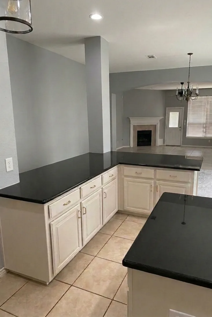 White painted kitchen cabinets with dark granite countertops by Masco Pros in McKinney, TX
