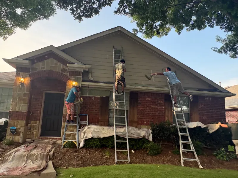 Masco Pros exterior painters on ladders prepping and painting a brick home in McKinney, TX