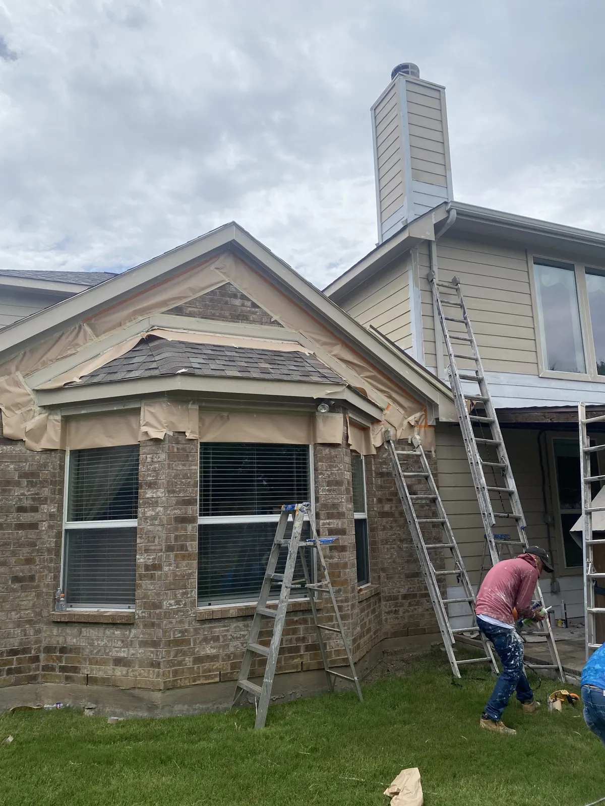Masco Pros crew masking windows and prepping a brick and siding home for exterior painting in McKinney, TX