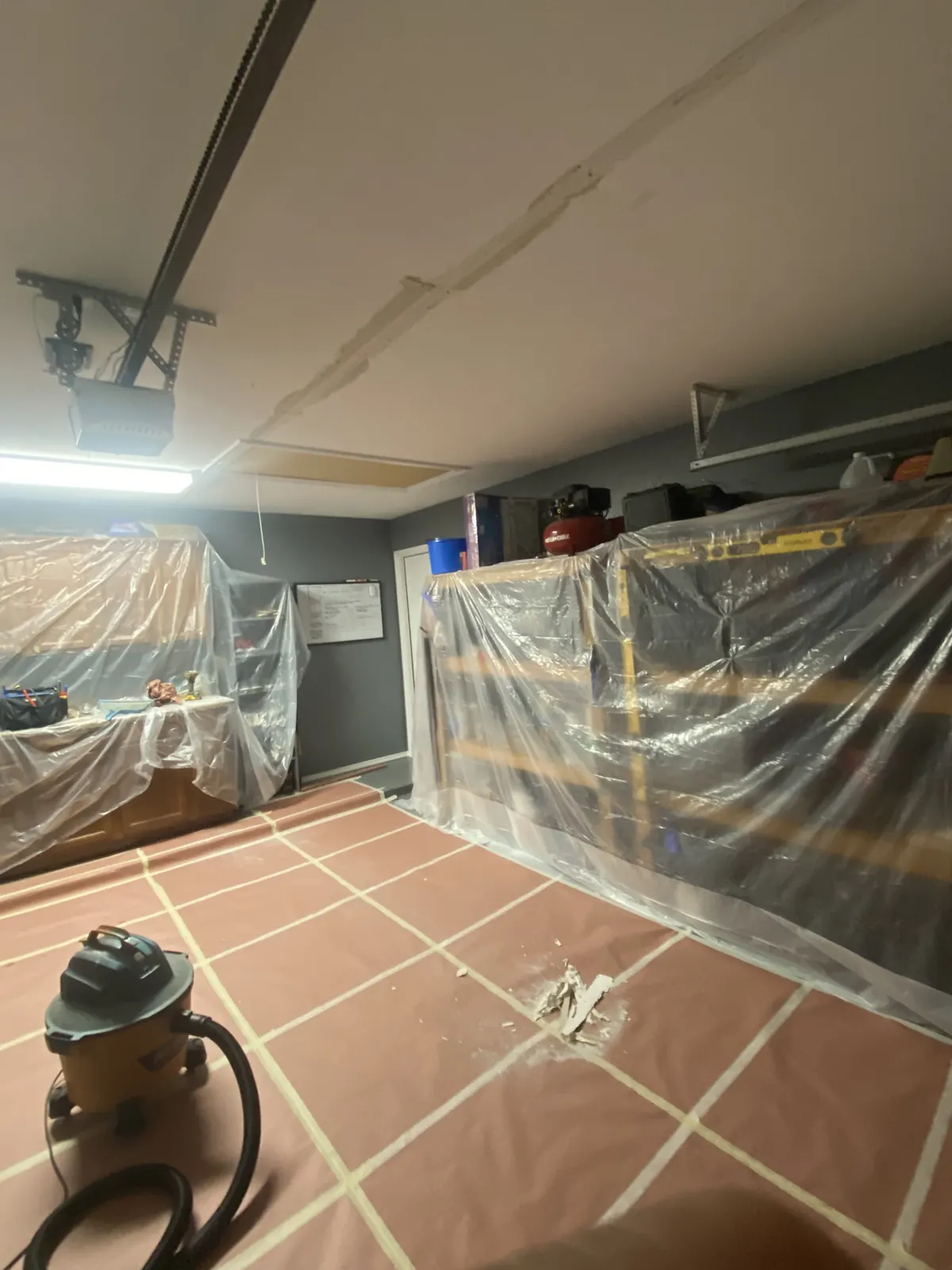 Garage drywall ceiling repair with taped seams and protected shelving in McKinney, TX