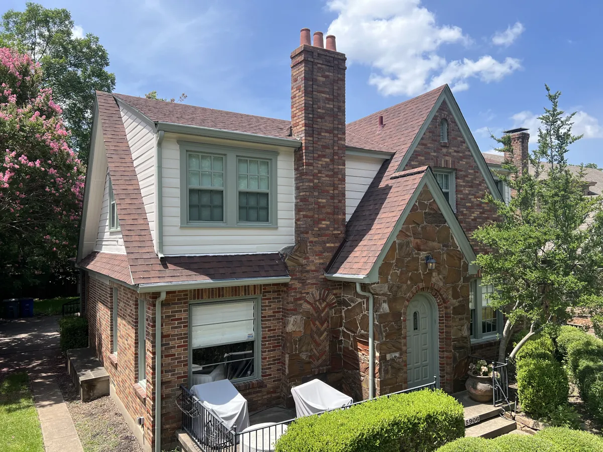 Two-story Tudor home with new white siding paint and sage green trim in McKinney, TX