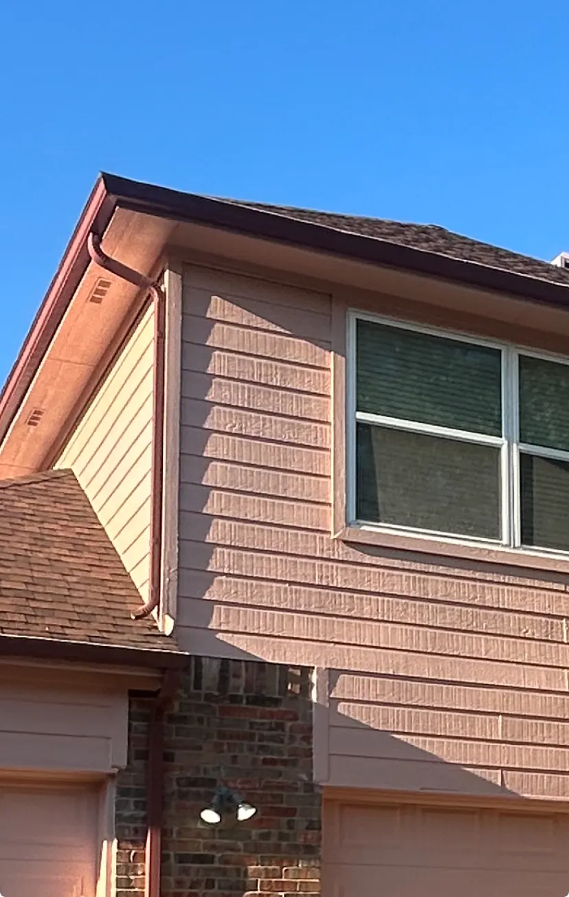 Color-matched gutters and downspout installed on a two-story home in McKinney, TX