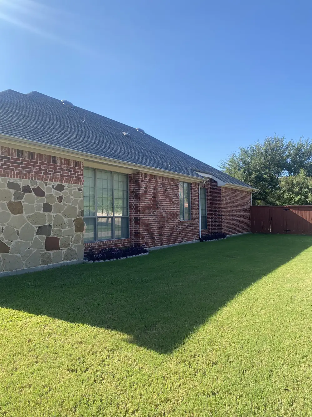 New seamless gutters and downspout installed on a brick home in McKinney, TX by Masco Pros