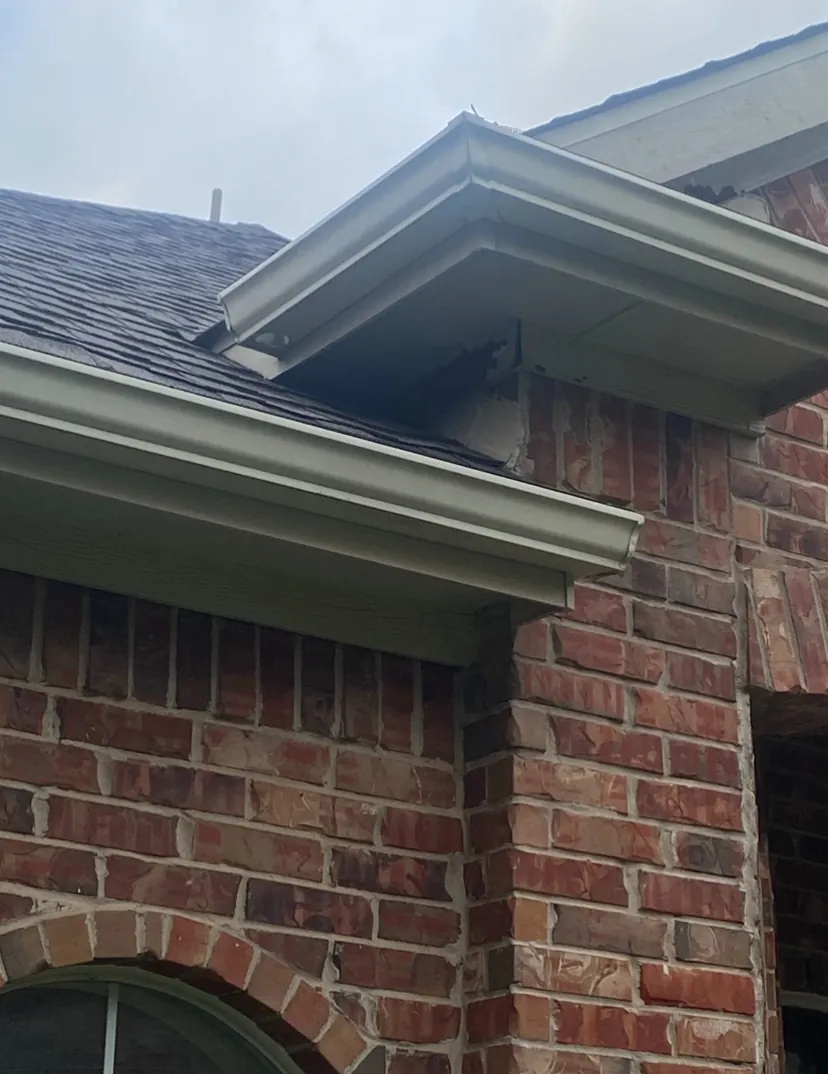Close-up of a seamless gutter corner and fascia on a brick home in McKinney, TX