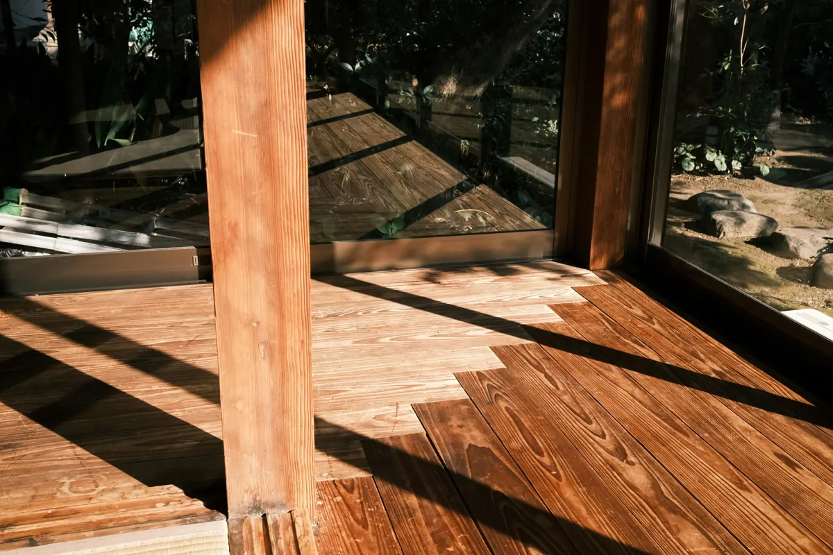 Covered wood deck with a freshly stained finish glowing in afternoon sun